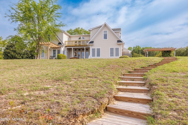 back of property featuring stairway and a lawn