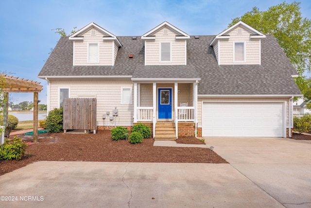 cape cod-style house featuring driveway, a garage, roof with shingles, a porch, and a pergola