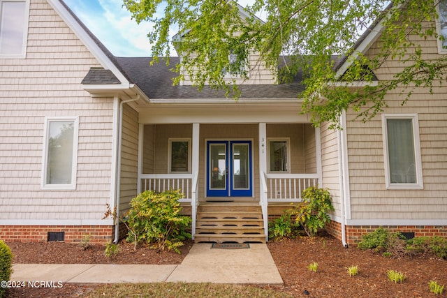 entrance to property featuring covered porch, roof with shingles, and crawl space