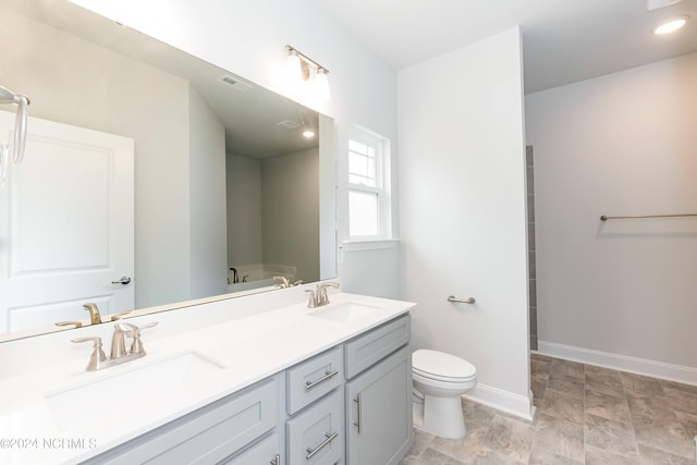 bathroom with tile floors, vanity with extensive cabinet space, toilet, and double sink