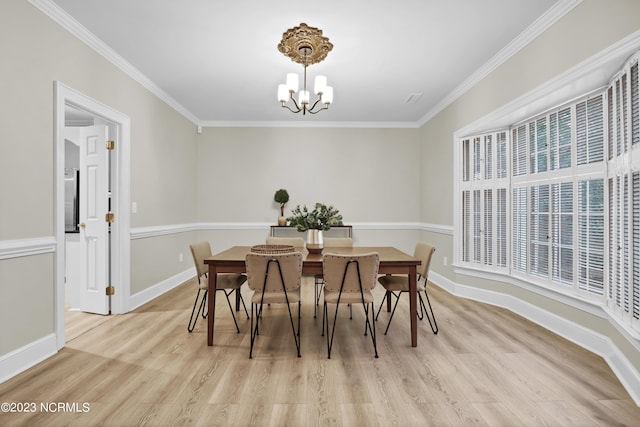 dining room featuring crown molding, a chandelier, and light wood-type flooring