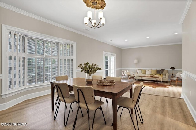 dining room featuring an inviting chandelier, crown molding, and light hardwood / wood-style flooring