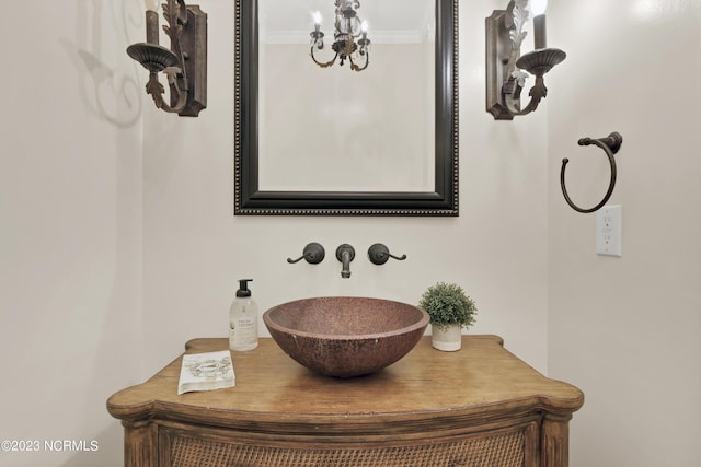 room details featuring crown molding, vanity, and a notable chandelier