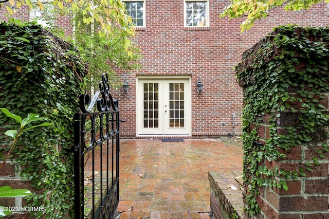 view of exterior entry featuring french doors and a patio area