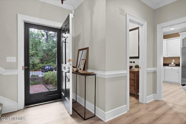 entryway with crown molding and light hardwood / wood-style floors