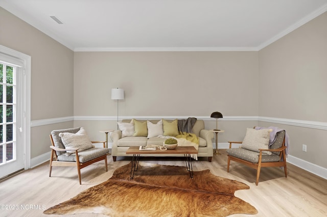 living area with crown molding and light hardwood / wood-style floors