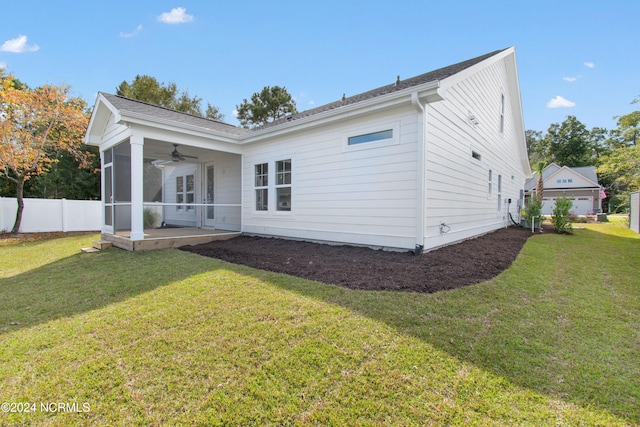 rear view of house with ceiling fan, a lawn, and a patio area