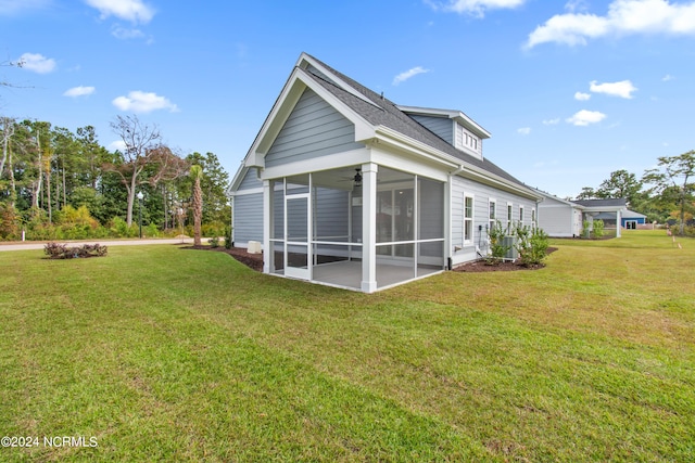 rear view of house featuring a lawn and a sunroom