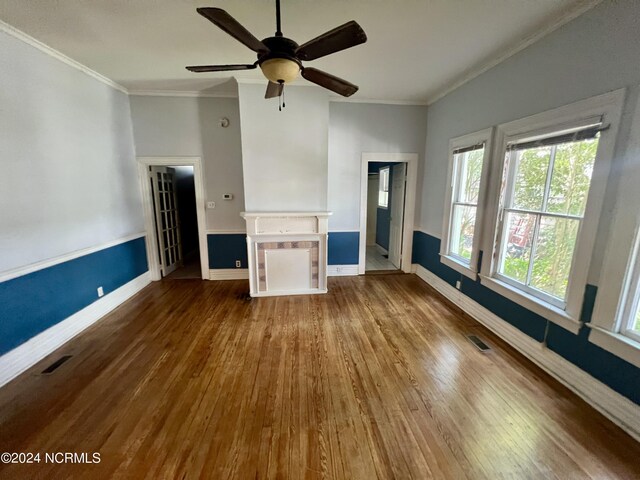 unfurnished living room with ornamental molding, a fireplace, ceiling fan, and dark wood-type flooring