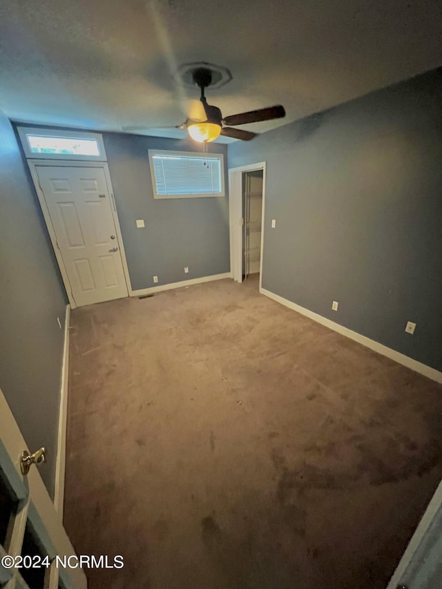 unfurnished bedroom featuring ceiling fan and carpet flooring