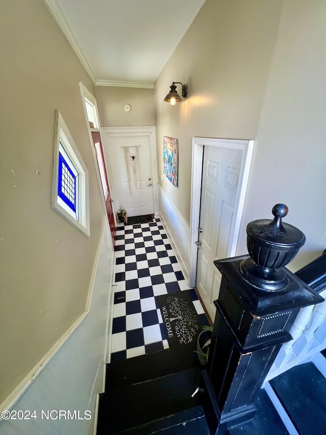 doorway featuring crown molding, baseboards, and tile patterned floors