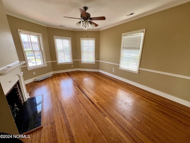 unfurnished living room with a wealth of natural light, wood-type flooring, and ceiling fan