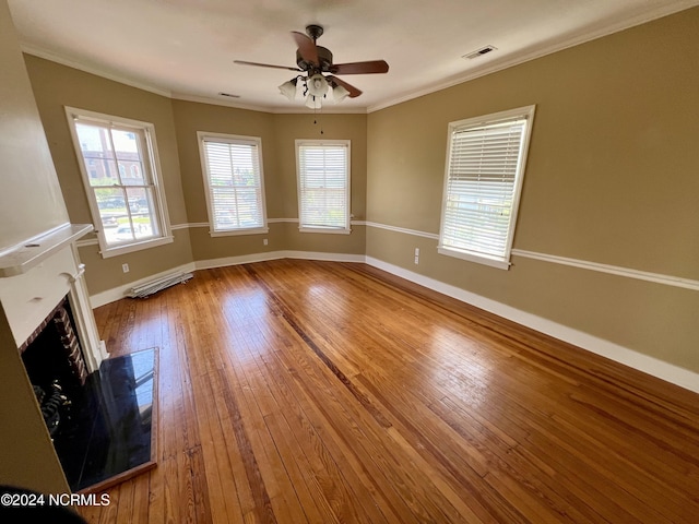 unfurnished living room featuring baseboards, visible vents, wood-type flooring, ornamental molding, and a fireplace