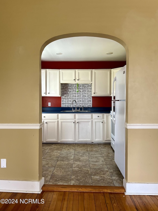 kitchen featuring sink, tasteful backsplash, white cabinets, and tile patterned floors