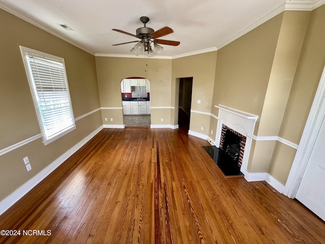 unfurnished living room featuring ceiling fan, hardwood / wood-style flooring, and ornamental molding