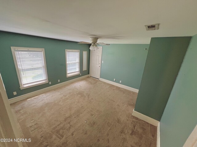 carpeted spare room with ceiling fan