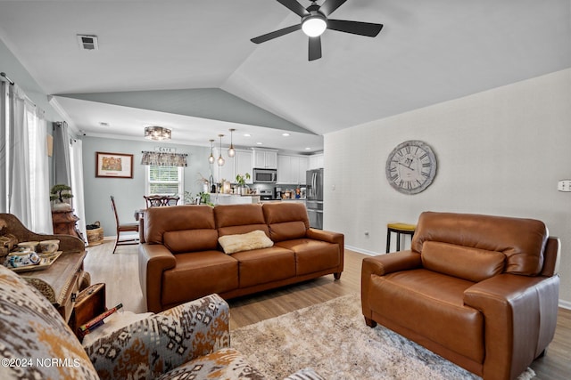 living room with ceiling fan, high vaulted ceiling, and light hardwood / wood-style flooring