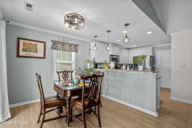 dining area featuring light hardwood / wood-style floors and ornamental molding