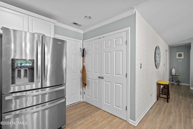 kitchen featuring light hardwood / wood-style flooring, stainless steel refrigerator with ice dispenser, ornamental molding, vaulted ceiling, and white cabinetry