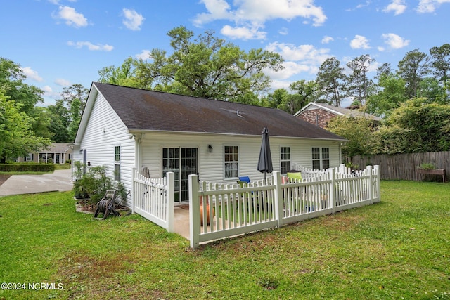 rear view of house featuring a patio area and a yard