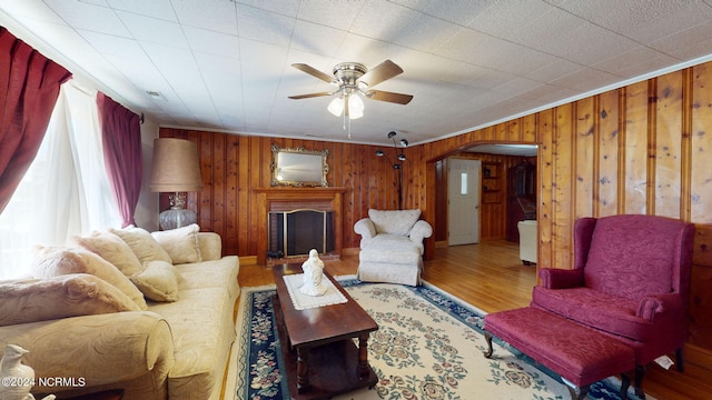 living room featuring crown molding, hardwood / wood-style floors, and wood walls