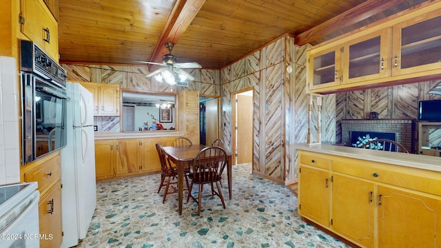 kitchen with a fireplace, oven, ceiling fan, white range, and wooden walls