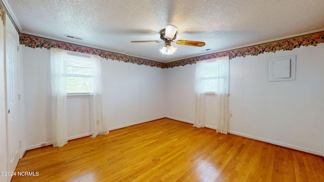 empty room featuring a textured ceiling, ceiling fan, and light wood-type flooring