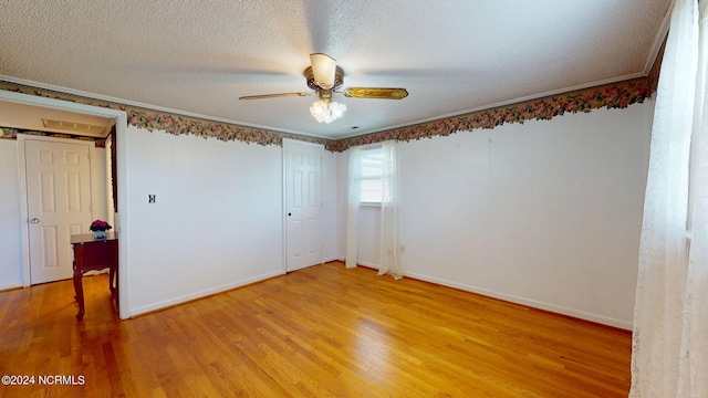 unfurnished bedroom featuring a textured ceiling, ornamental molding, ceiling fan, and light wood-type flooring