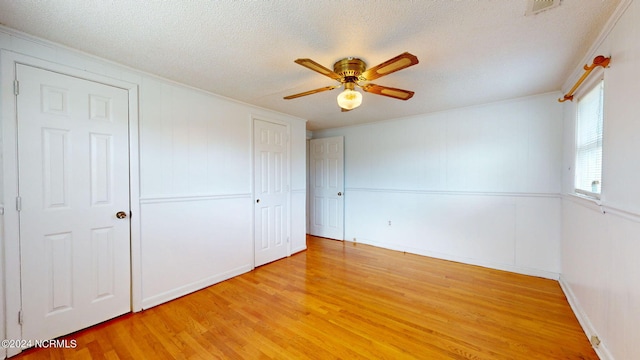 unfurnished bedroom featuring light hardwood / wood-style floors, a textured ceiling, and ceiling fan