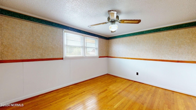 empty room with a textured ceiling, light wood-type flooring, and ceiling fan