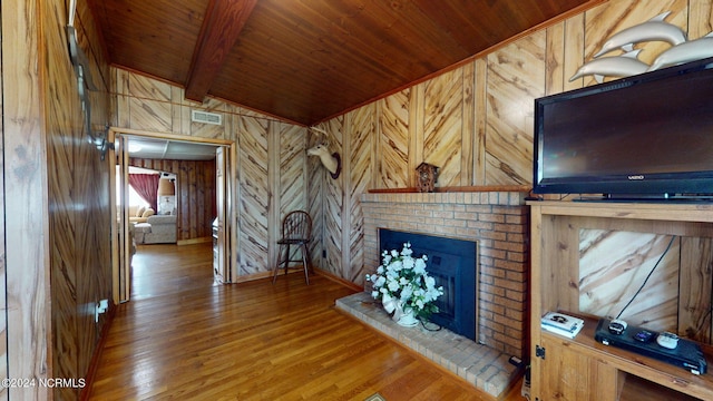 unfurnished living room with a brick fireplace, wooden walls, hardwood / wood-style flooring, and wooden ceiling