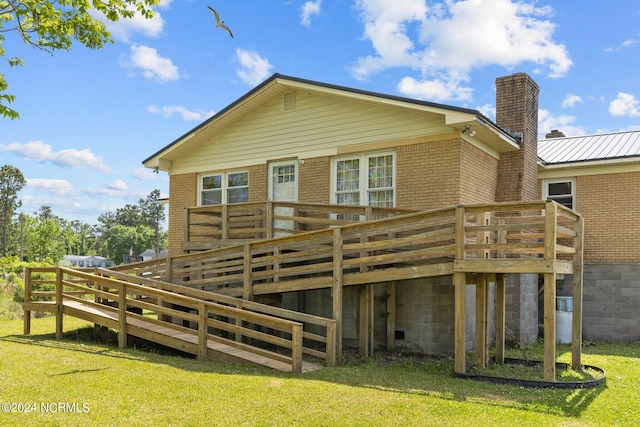 rear view of house featuring a lawn and a deck