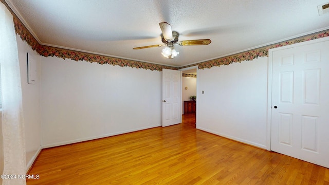 unfurnished bedroom with a textured ceiling, ceiling fan, light wood-type flooring, and crown molding