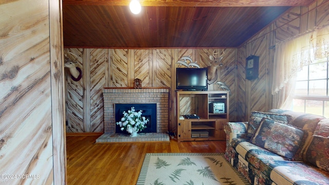 living room featuring wooden ceiling, a brick fireplace, wood walls, and hardwood / wood-style floors