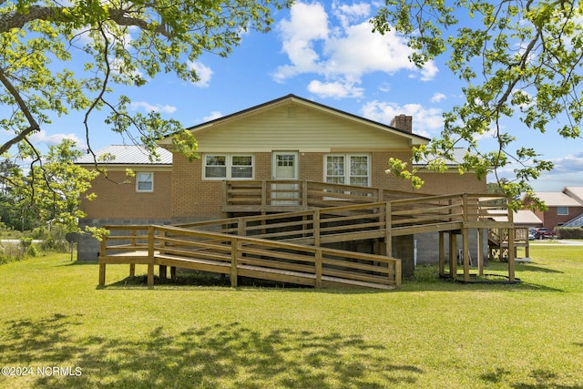 rear view of house with a deck and a yard