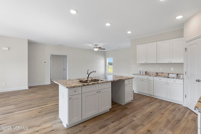 kitchen featuring white cabinetry, ceiling fan, and sink