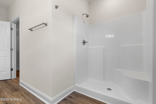 bathroom with hardwood / wood-style flooring and a shower