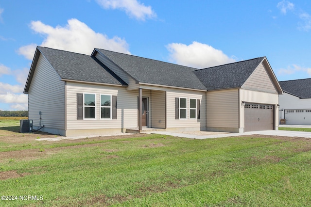 view of front facade with a garage, a front lawn, and central air condition unit