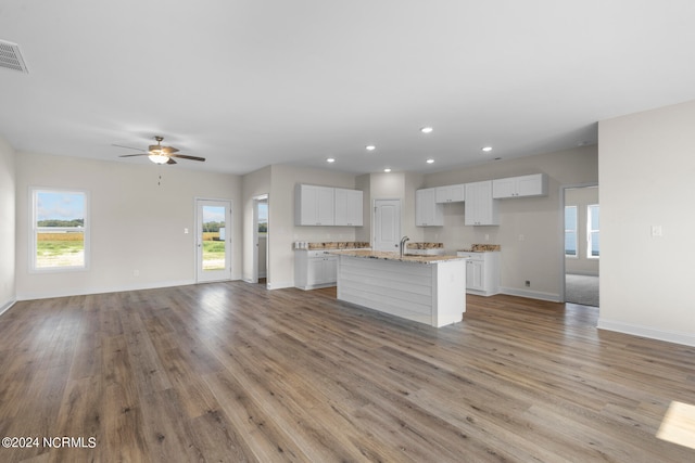 kitchen with ceiling fan, white cabinets, a kitchen island with sink, and light hardwood / wood-style flooring