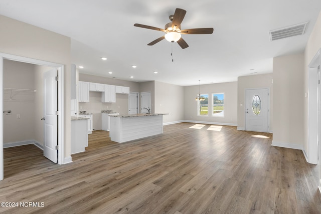 unfurnished living room featuring ceiling fan, hardwood / wood-style flooring, and sink