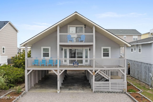 back of house with a balcony and a carport