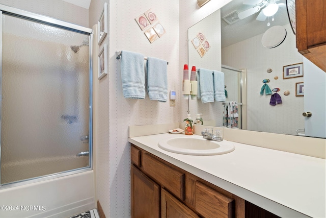 bathroom featuring ceiling fan, vanity, and combined bath / shower with glass door