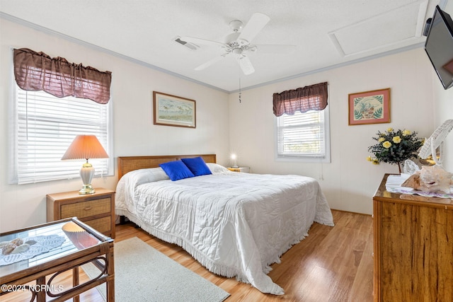 bedroom with ornamental molding, ceiling fan, and light wood-type flooring