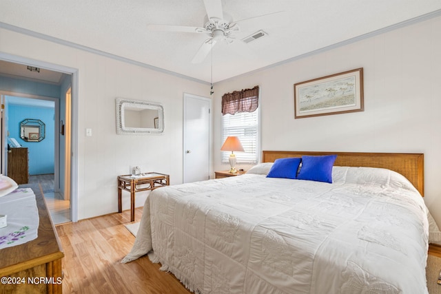 bedroom with crown molding, ceiling fan, and hardwood / wood-style floors