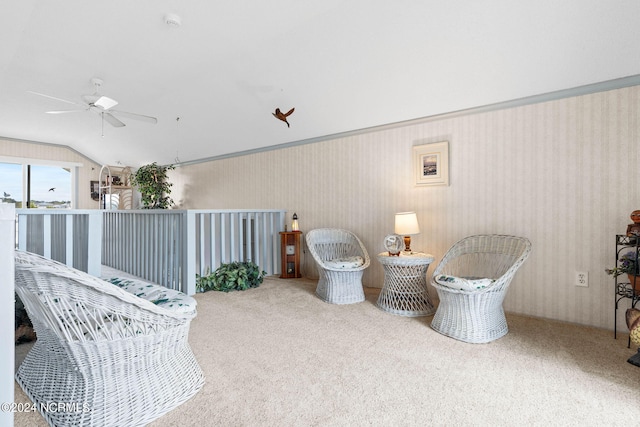 living area featuring carpet flooring, ceiling fan, and vaulted ceiling