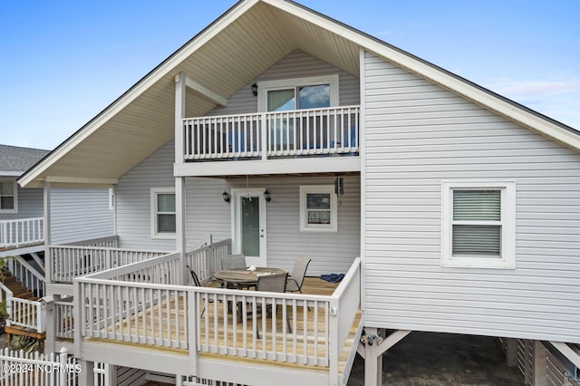 rear view of property with a wooden deck and a balcony