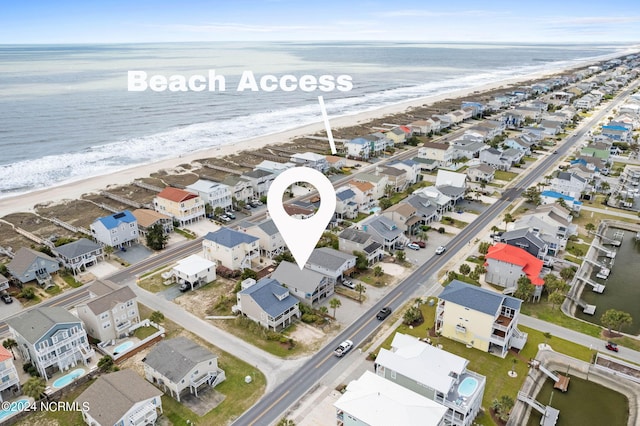 birds eye view of property featuring a beach view and a water view