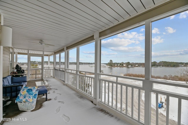 sunroom featuring a water view and ceiling fan