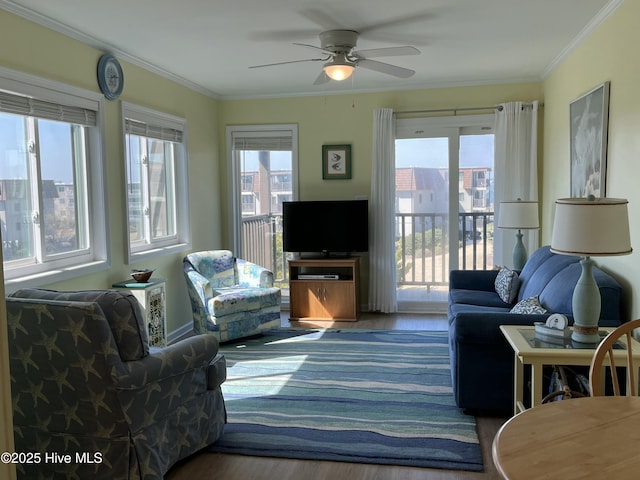 living room with crown molding, plenty of natural light, and wood finished floors