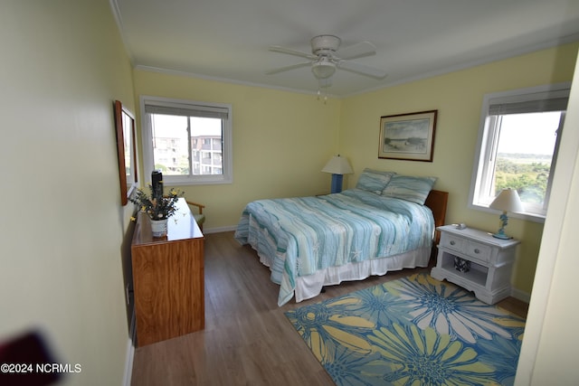 bedroom with ornamental molding, multiple windows, and wood finished floors